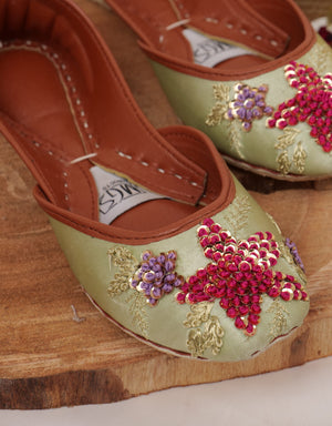 Close-up of pink sequin embellishment on pistachio green jutti