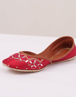 Close-up of red jutti with gold floral embroidery