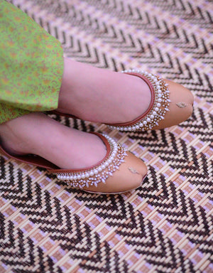 Close-up of mustard yellow jutti with gold-tone detailing
