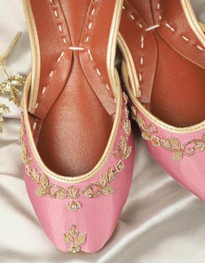 Close-up of baby pink jutti with gold floral work and crystal-style accents